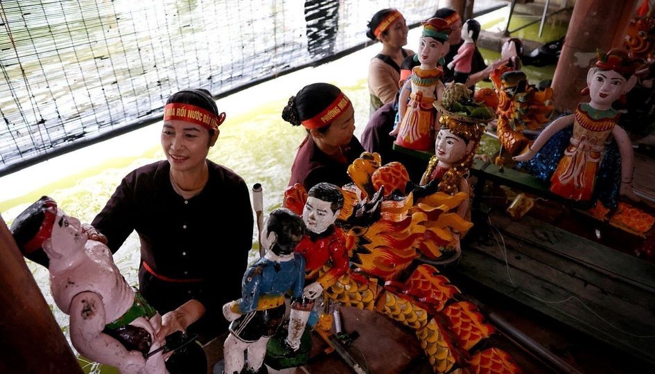 Dao Thuc water puppeteers preparing hand-painted figures near Hanoi